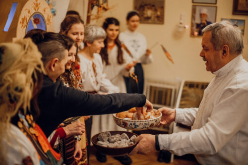 The_host_of_the_house_treats_the_members_of_the_nativity_scene_with_national_Ukrainian_Christmas_sweets